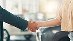 Closeup, salesman and customer with handshake in car dealership, test drive or success purchase of motor. Showroom, people and agreement with shaking hands for buying vehicle, rental service or flare