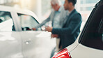 Salesman, men and discussion by car at dealership with sale, negotiation and finance planning at shop. Client, people and agent for test drive, purchase and blur for deal with vehicle at showroom