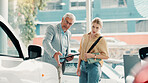 Tablet, customer and salesman with discussion for car dealership, transport and motor for rental service. Showroom, woman and mature seller with tech for assistance, vehicle features and conversation