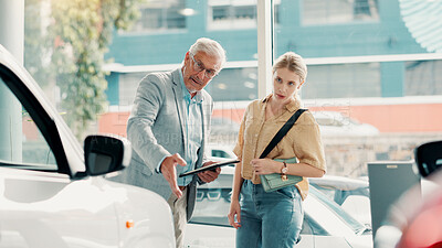 Buy stock photo Tablet, customer and salesman with discussion for car dealership, transport and motor for rental service. Showroom, woman and mature seller with tech for assistance, vehicle features and conversation