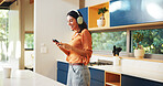 Phone, headphones and woman in kitchen in home listening to music, playlist or album on mobile app. Audio tech, cellphone and female person with online networking and streaming radio in apartment.