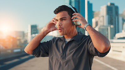 Buy stock photo Breathing, fitness and music with man in city for break from cardio training or running. Exercise, fatigue and headphones with athlete or runner outdoor in urban town for sports, vision or workout