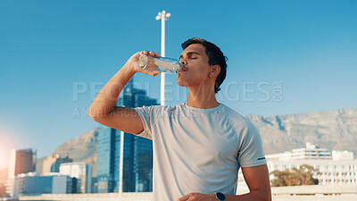 Buy stock photo Man, fitness and drinking water in city for break, natural sustainability or refreshment. Active, male person or thirsty runner with mineral liquid, aqua or beverage for hydration, recovery or rest