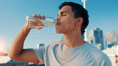 Buy stock photo Man, fitness and drinking water in city for hydration, natural sustainability or refreshment. Active, male person or thirsty runner with mineral liquid, aqua or beverage for recovery, rest or break