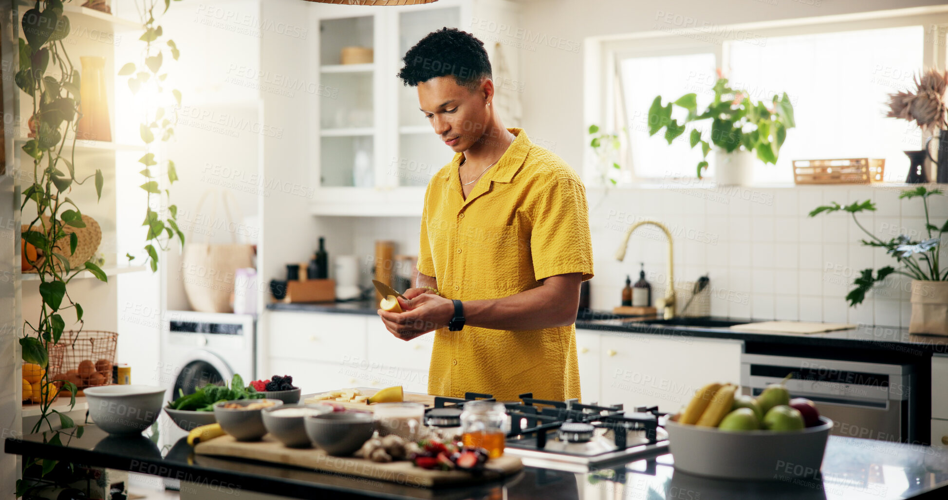 Buy stock photo Banana, cooking and concentration with man in kitchen of home for hobby, meal prep or nutrition. Ingredients, peeling and recipe with person in apartment for diet, health or supper as culinary chef