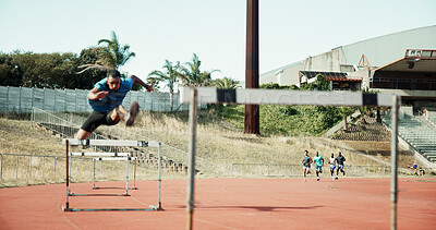 Sprint, jump and male athlete by hurdle for fitness competition, challenge and contest at sports field. Man, obstacle and race with people for speed, leap and performance at low angle for marathon