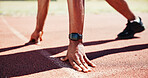 Hands, start line and athlete on track for race, speed or ready for competition, contest or fitness in summer. Person, runner and smart watch for sprint, exercise and feet on circuit at sports club