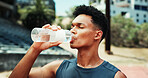 Stadium, man and fitness with drinking water for wellness, hydration and nutrition on workout break. Outdoor, male person and athlete with bottle for h2o liquid, detox and beverage after exercise