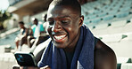 Athlete, man and happy with phone on stadium for workout post, streaming service or social media scroll. Fitness, runner and smartphone at sports arena for practice break, text message or mobile chat