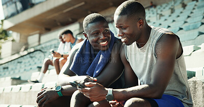Buy stock photo Sports, stadium and athlete friends with phone, smile and checking online schedule at team practice together. Relax, smartphone and men in bleachers for fitness app, progress tracking or workout plan