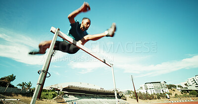 Buy stock photo Man, jump and track with hurdles, training and motion blur with equipment, speed and exercise in summer. African person, low angle and athlete with space, fitness and sports at stadium in Kenya