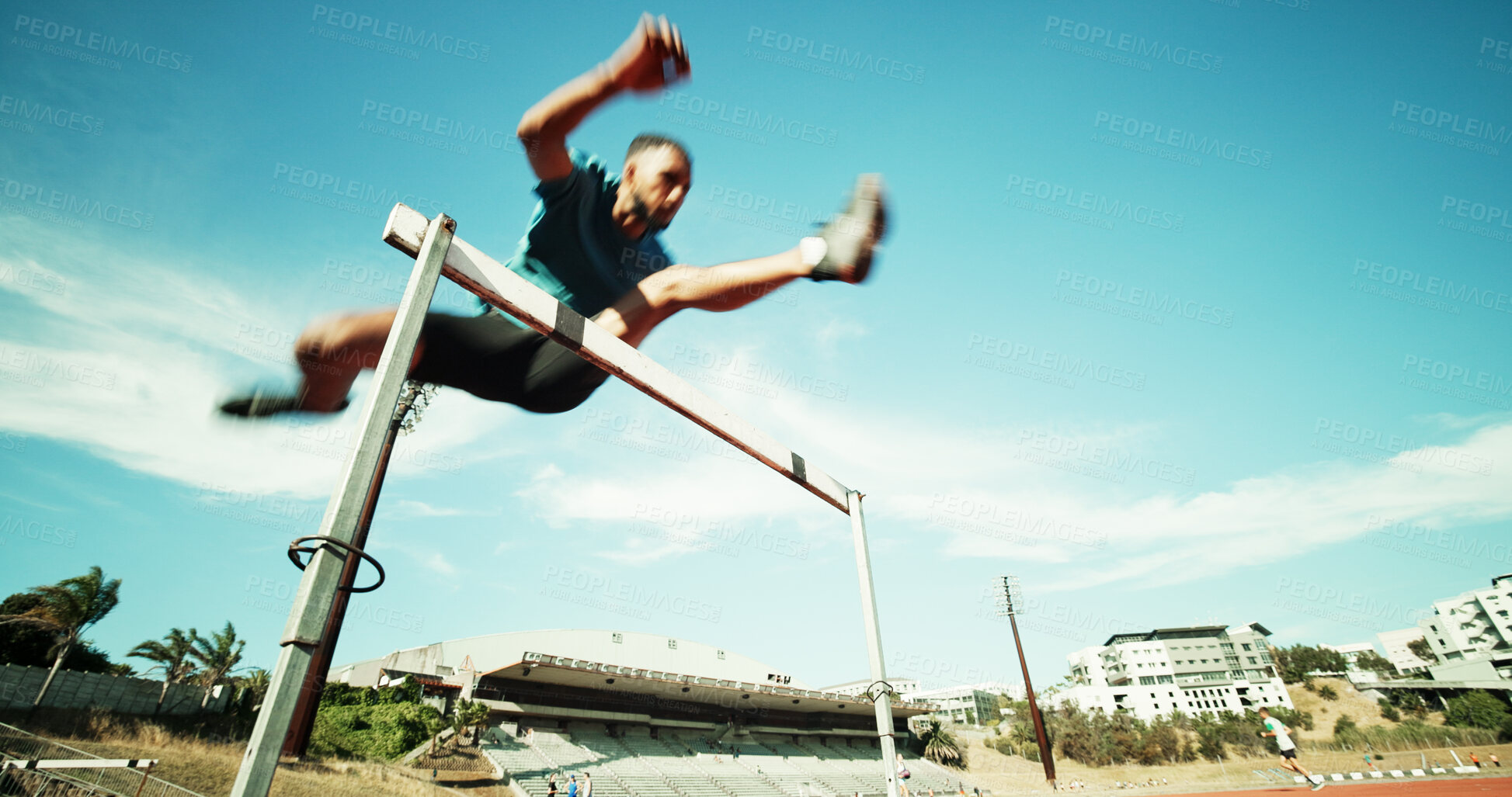 Buy stock photo Man, jump and track with hurdles, training and motion blur with equipment, speed and exercise in summer. African person, low angle and athlete with space, fitness and sports at stadium in Kenya