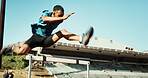 Man, athlete and sprint or jump by hurdle for fitness competition, challenge and contest at sports field. Male person, obstacle and race with people for speed, leap and performance for marathon event