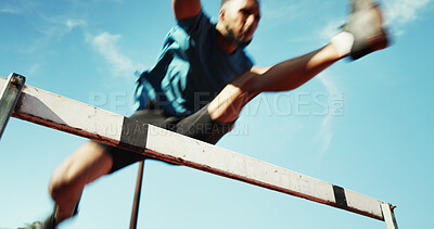 Buy stock photo Man, athlete and jump by hurdle for fitness competition, challenge and contest at sports field. Blur person, obstacle and low angle sprint for speed, leap and performance for marathon event by sky