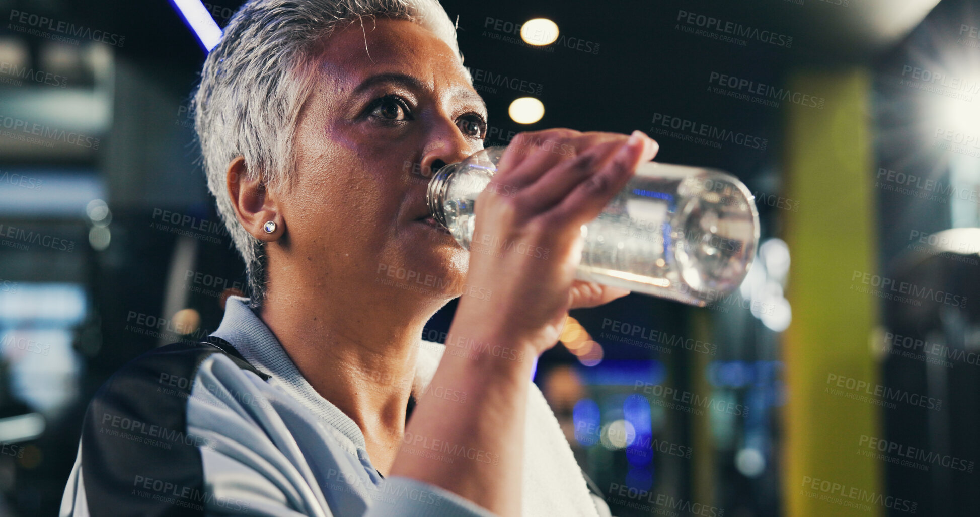 Buy stock photo Drinking water, fitness and woman in gym, thirsty and healthy with training, tired and workout. Mature person, liquid or bottle in wellness center, nutrition and minerals with electrolytes or fatigue