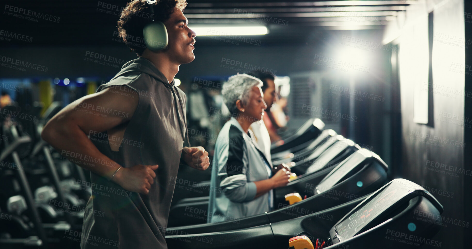Buy stock photo Workout, man and running on treadmill with headphones at night for speed training, endurance challenge and playlist. Fitness, evening exercise and music for calorie burning and cardio routine at gym
