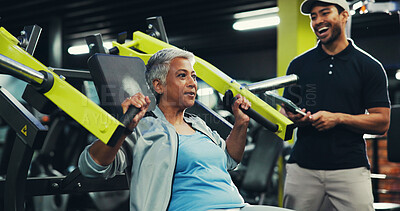Buy stock photo Instructor, senior woman and machine at gym for chest press, muscle strength or training performance. Retirement fitness, personal trainer and tablet for workout progress, exercise monitor or support