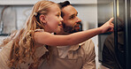 Kitchen, father and child by oven for baking, learning and bonding together with happy expression. Home, parent and dad with pointing girl for cooking, teaching and family waiting for stove in house