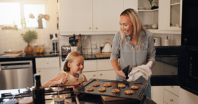 Buy stock photo Baking, child and mom with cookies in kitchen, teaching and helping daughter with meal prep in home. Excited, woman and showing dessert to kid, family and happy for culinary skills in apartment