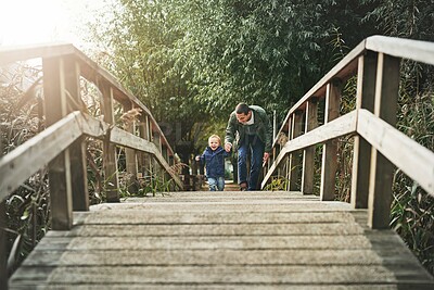 Buy stock photo Walking, bridge and child in park with father for playing, explore and adventure for fun outdoors. Childhood, nature and dad with young toddler for journey to enjoy vacation, holiday and weekend