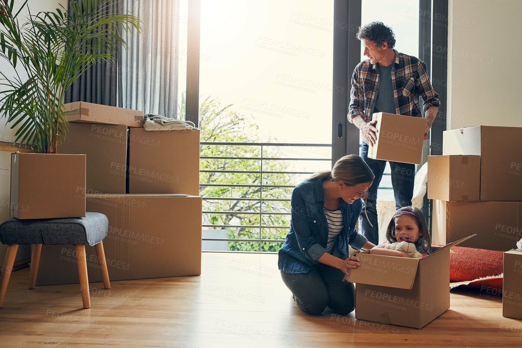 Buy stock photo Moving, boxes and parents with child in new house bonding together for family time at property. Relocation, mortgage and scared girl kid in cardboard with mom and dad unpacking packages for home.