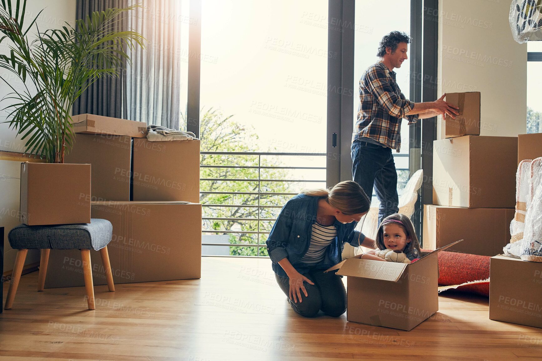 Buy stock photo Moving, boxes and parents with kid in new home bonding together for family time at property. Relocation, mortgage and girl child play with mom and dad and unpacking cardboard package for house.