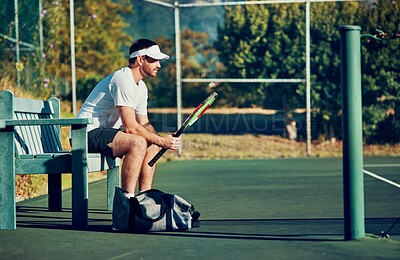 Buy stock photo Man, tennis and waiting with racket for sport, game or match on bench at outdoor court. Young, male person or athlete with bat for break, rest or half time in competition, tournament or practice