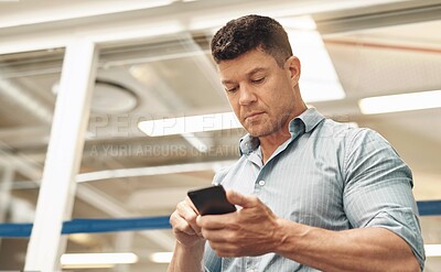 Buy stock photo Businessman, typing and phone with app for social media, communication or reading news at office. Young, man or employee with mobile smartphone for online chatting, texting or connection at workplace