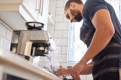 Buy stock photo Mexican man, coffee and machine at home in kitchen to steam or warm milk to relax, chill and rest. House, cappuccino and low angle on countertop, hot and fresh to clean, hygiene and apron as routine
