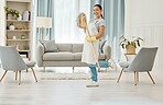 Cleaning, chores and hygiene with a woman cleaner or domestic worker with a mop in a house to clean, tidy and wash. Housework, hygienic and sanitizing with a young female in a home living room