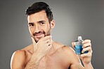 Man, perfume and cologne product in studio for hygiene, fresh scent and fragrance on gray background. Parfum, wellness and happy male model thinking about spray cosmetics to prevent odor or smell.

