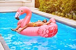 Man, summer and flamingo in swimming pool for holiday, wellness and relax for vacation. Male person, sunshine and inflatable bird in water for travel, calm or zen and float for weekend trip to Miami