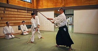 Buy stock photo Dojo, class and mentor in Aikido training in gym with wood sword Japanese martial arts and fight exercise in wellness studio. Learning, sport and weapon with people and strike practice for defence