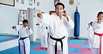 Punch, man and children in karate class, self defense training or martial arts for youth for combat education with sensei. Taekwondo, fight and male instructor with student kids for coaching in dojo