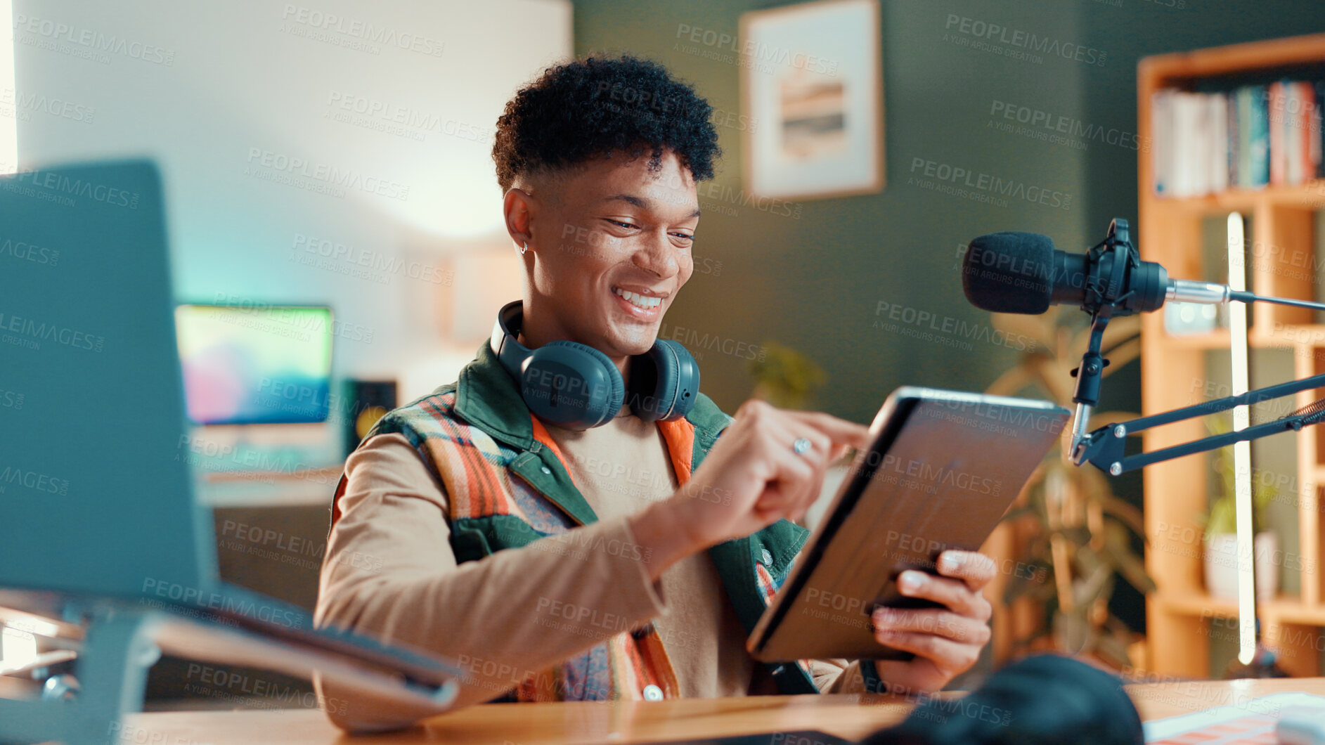 Buy stock photo Man, streamer and tablet in home with mic, typing and smile with script editing for video production. Influencer, happy and app for chat with fans, click or subscription list on social media at house