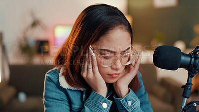 Buy stock photo Woman, headache and mic for live stream, stress or eyes closed for injury at apartment. Gen z girl, influencer and frustrated with migraine, pain or burnout with podcast recording in home