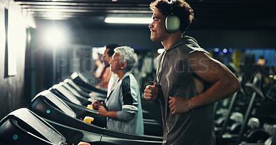 Buy stock photo Fitness, man and running on treadmill with headphones at night for cardio, exercise and music. Athlete, evening workout and audio playlist for calorie burning, agility training and speed development