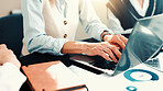 Hands, laptop and typing at meeting, finance and report for revenue growth with charts at office. Person, accounting and staff with computer for review, feedback and audit with documents at agency