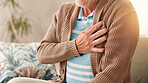 Elderly man, hands and sofa with chest pain for medical emergency or cardiac arrest at home. Closeup, senior or male person with discomfort or lung disease for heartburn or heart attack at house