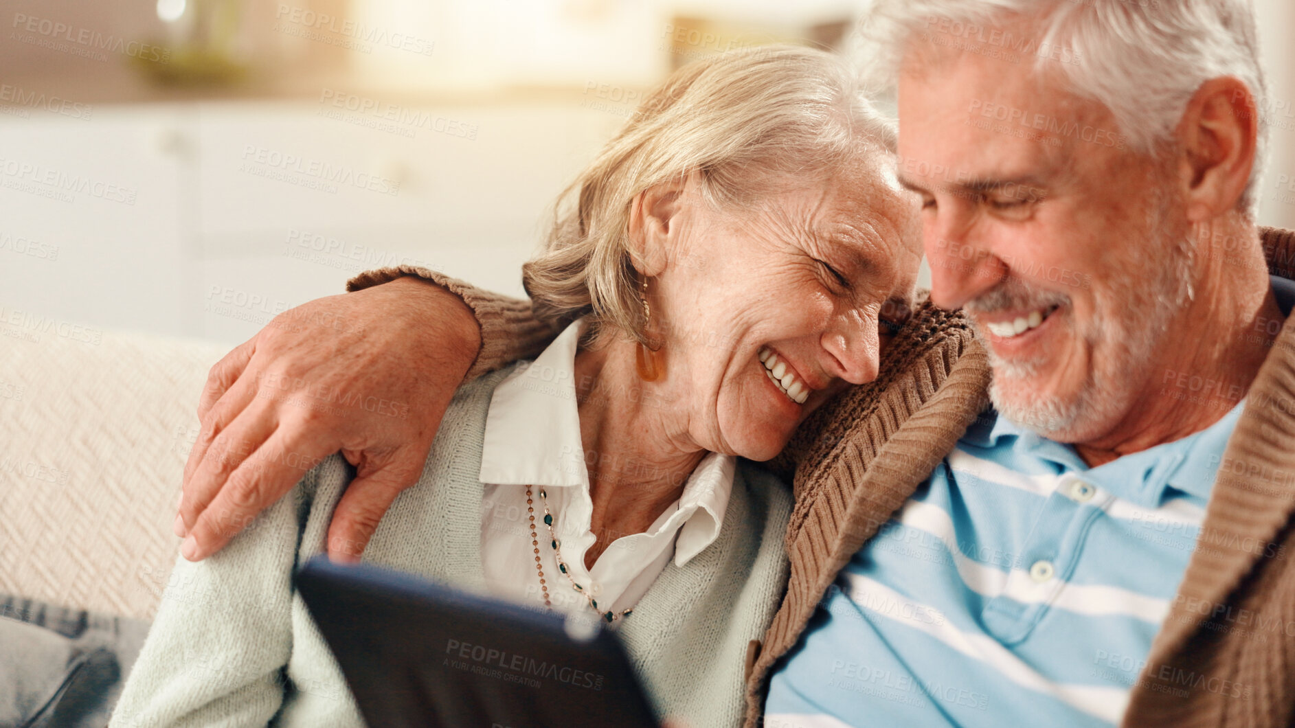 Buy stock photo Senior couple, tablet and laugh on sofa in home with hug, happy and relax with film in living room. Elderly man, woman and digital touchscreen with app for funny movies, comedy or video in retirement
