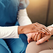 Holding hands, closeup and senior woman with nurse on sofa for comfort ...