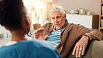 Nurse, talking and healthcare with old man on sofa for occupational therapy, advice and consulting. Medical, caregiver and retirement with senior person in nursing home for wellness and support