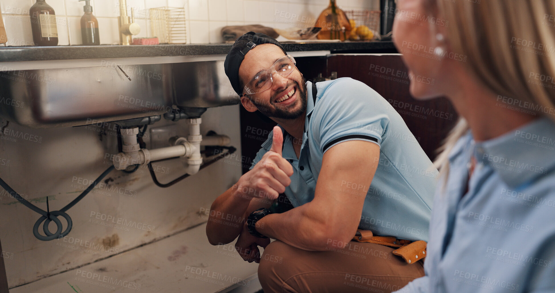 Buy stock photo Plumber, woman and thumbs up for repair by kitchen sink for leak, drain and maintenance in home. Handyman, client and sign for yes, finished and smile for services with deal for solution at apartment