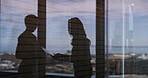 Discussion, shadow and business women in office by window with documents for finance report. Meeting, paperwork and silhouette of female financial advisors with company budget planning in workplace.