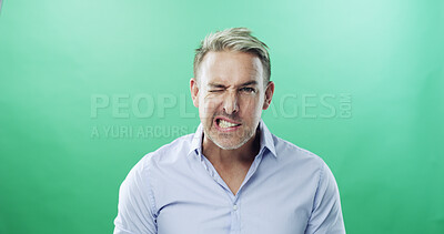 Buy stock photo Frustrated, portrait and businessman in studio with wink, eye signal or anger in corporate crisis. Green background, furious face and upset manager grinding teeth with problem, stress or mockup space