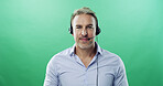 Businessman, portrait and consultant with headset on green background for communication in studio. Male person, agent or model with smile or mic for online advice or customer service on mockup space