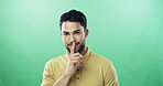 Portrait, man and shush for secret in studio for gossip, privacy sign and silence for rumor. Person, mockup space and quiet gesture for mystery, confidential news and announcement on green background
