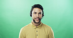 Man, headset and happy in studio for call center, advice and mockup space with talk by green background. Person, agent and sales consultant with voip mic, contact us or smile for customer support