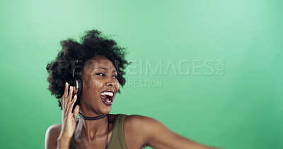 Buy stock photo Dance, music and singing with black woman in studio for energy, excitement or radio streaming. Sound, headphones and space with happy dancer person on green background for audio subscription