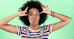 Portrait, funny and black woman in studio, silly and facial expression on green background. African person, space and happy model with confident personality, crazy and playful attitude with fun